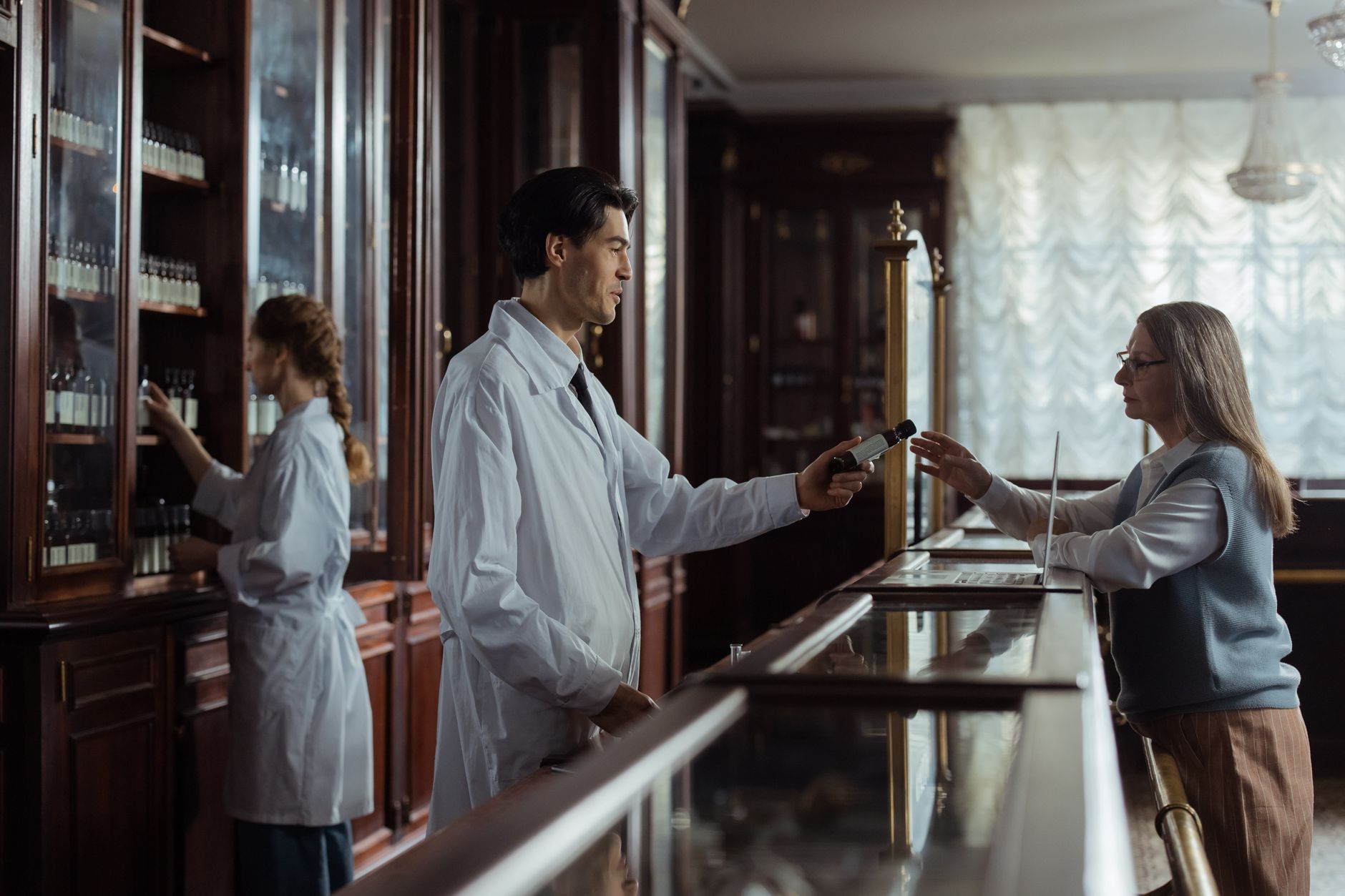 Farmacêutico atendendo cliente no balcão de uma farmácia tradicional